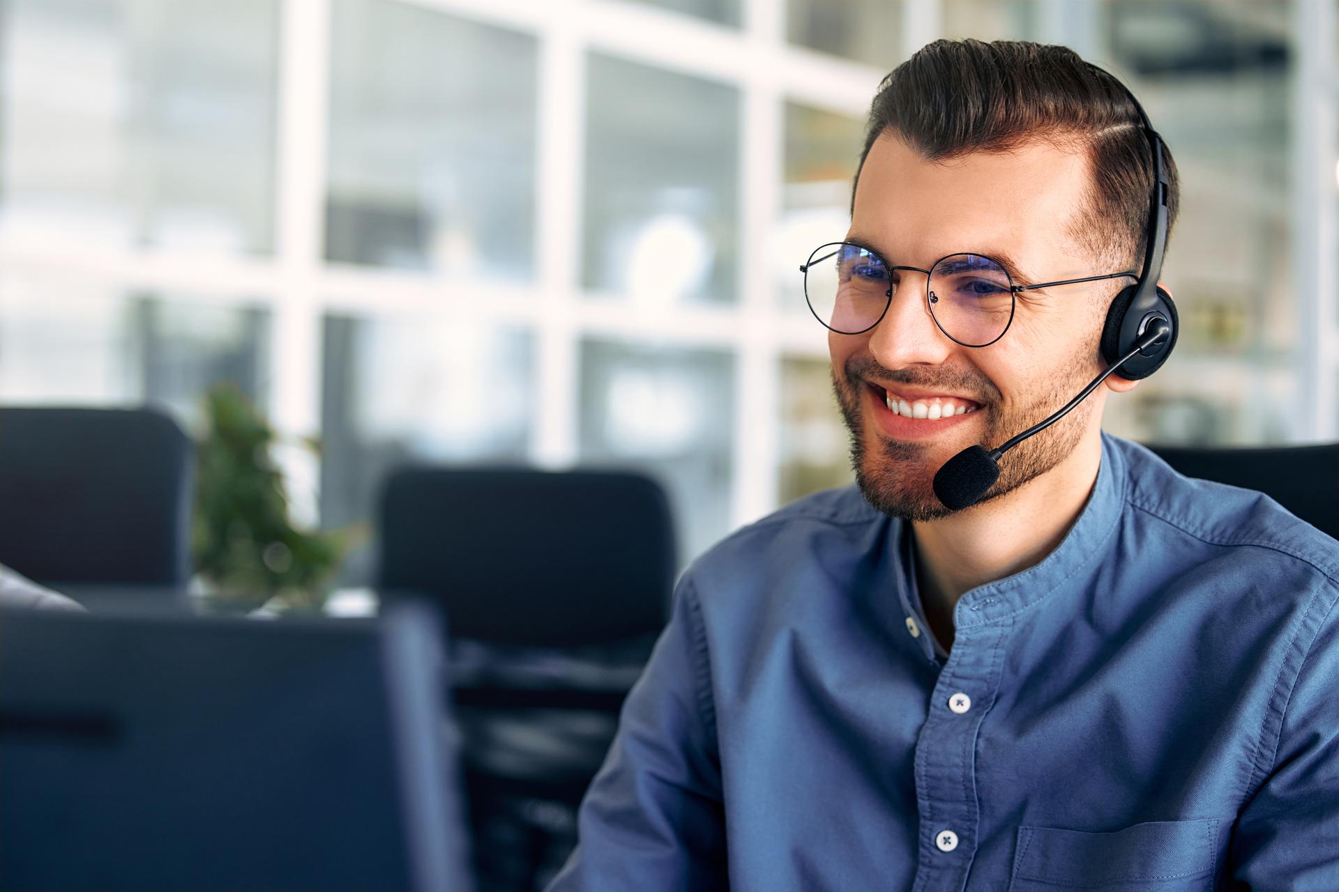 A call center worker sitting at a laptop in the office.